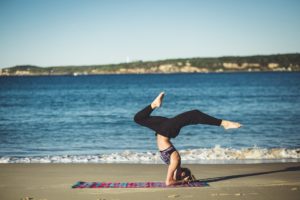 Woman practicing yoga on a beach uses integrative therapies