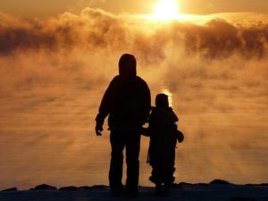 a child and adult in silhouette looking at sky thinking about their own death