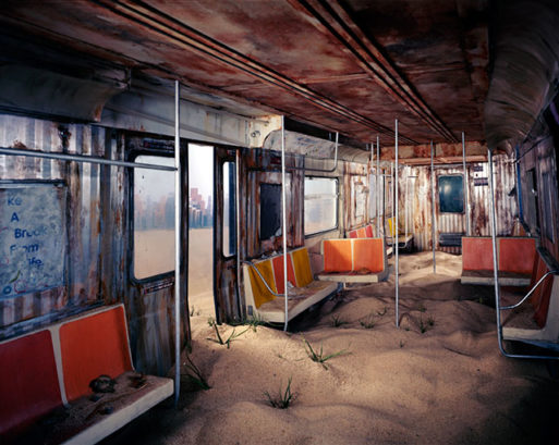 a deserted subway car filled with sand and debris