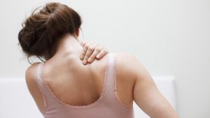 Woman rubbing a sore shoulder should take aspirin