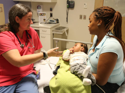 young African American women holds baby in doctor's office accessing healthcare