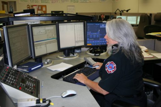 911 dispatcher looking at multiple screens