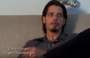 A screenshot of Chris Cornell sitting on a couch talking about Andrew Wood for the documentary 