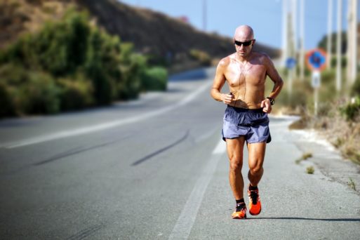Older man running along a road symbolizing physical activity