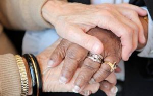 Two pairs of hands represent comfort for victims of elder abuse