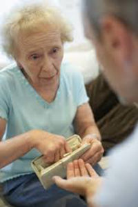 An elderly woman giving money to someone with their hand out may be a victim of elder abuse