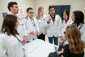 Medical students gathered around a patient discussing medical issues