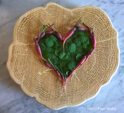 handmade heart made of tiny purple carrots inside a basket
