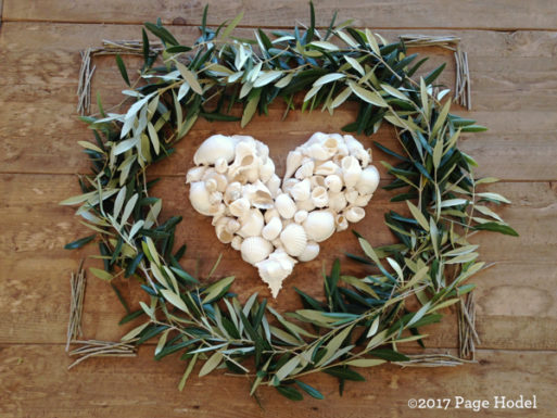 Heart made of seashells surrounded by a circle of leaves