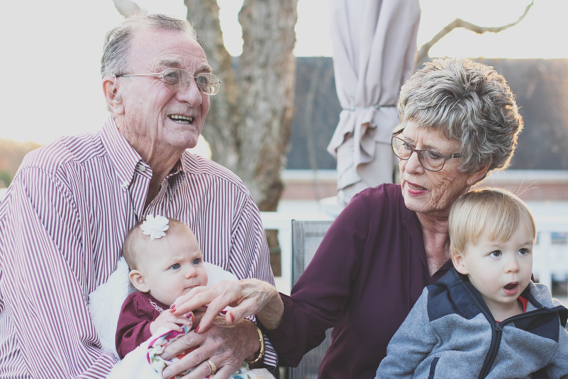 A photo of an older couple holding infants