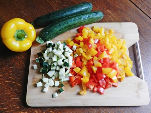 A chopping board with fresh vegetables sitting on top of it, which are part of a high-fiber diet