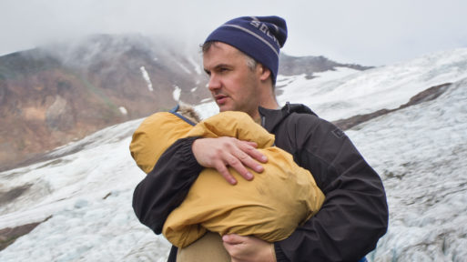 Phil Elverum, creator of "A Crow Looked at Me" holds his baby daughter outdoors in snow