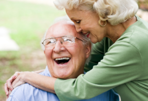Woman hugging a happy elderly man saying "I hope you had the time of your life"
