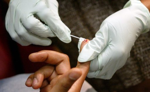 Person taking blood from a finger for HIV testing