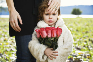 Young child holding roses at a funeral