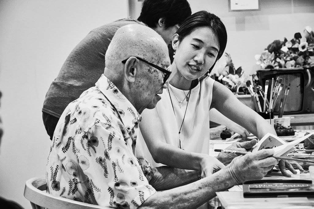 Elderly man works with hospice staff in photo by Alan Lee
