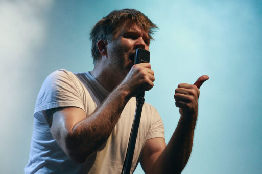 James Murphy of electronic group LCD Soundsytem singing "Something Great" into a microphone