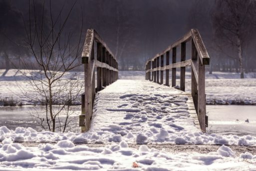 Wooden foot bridge covered in snow symbolizing the transition from life to death
