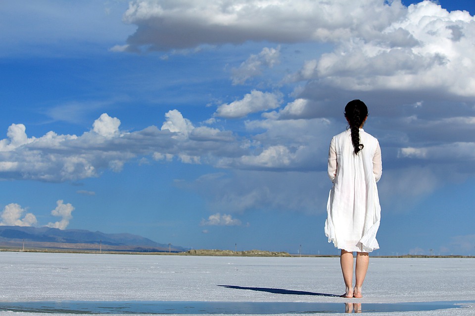 A woman stands outside, staring up at the clouds, similar to the narrator in Kyu Sakamoto's song about loss