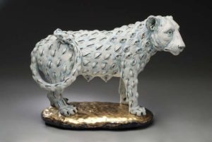 A sculpture about loss, featuring a grey lion that is covered in small eyeballs
