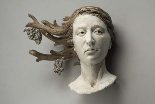 A sculpture about loss, featuring a woman's head, whose hair is being transformed into tree branches with two honeycombs hanging from the tips of the branches