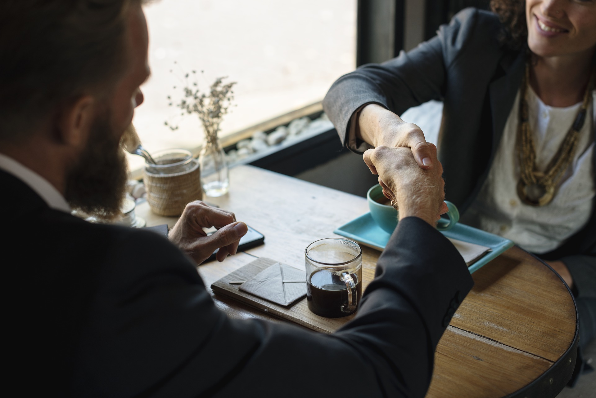 Man and woman shaking hands symbolizing a newly formed agreement and/or business relationship