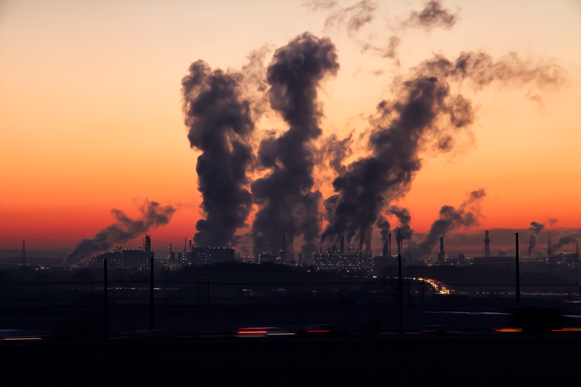 Factory smoke stacks emitting smoke at dusk