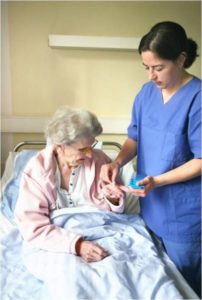 Nurse giving an elderly woman Nuedexta