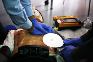 Two paramedics in training work on a CPR dummy, administering life-saving medical treatments