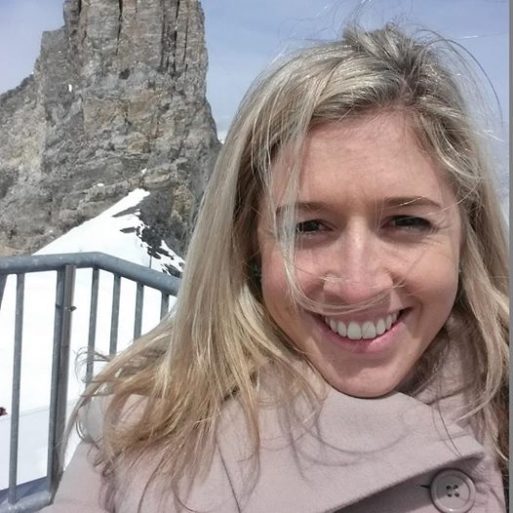 Selfie photo of Holly Butcher who wrote "a note before I die", wearing a coat standing in front of a rocky pillar with snow on the ground