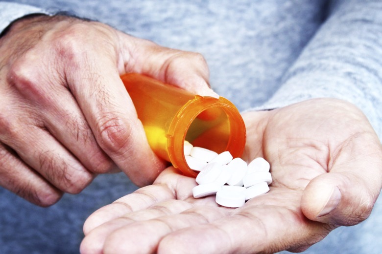 an old man's hands holding a bottle of pills gained by right to try laws