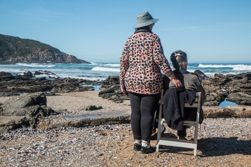 Two elderly women on a beach demonstrating cancer etiquette