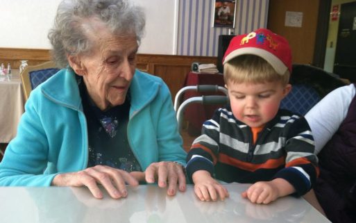 An elderly woman and young boy interact, demonstrating intergenerational interaction