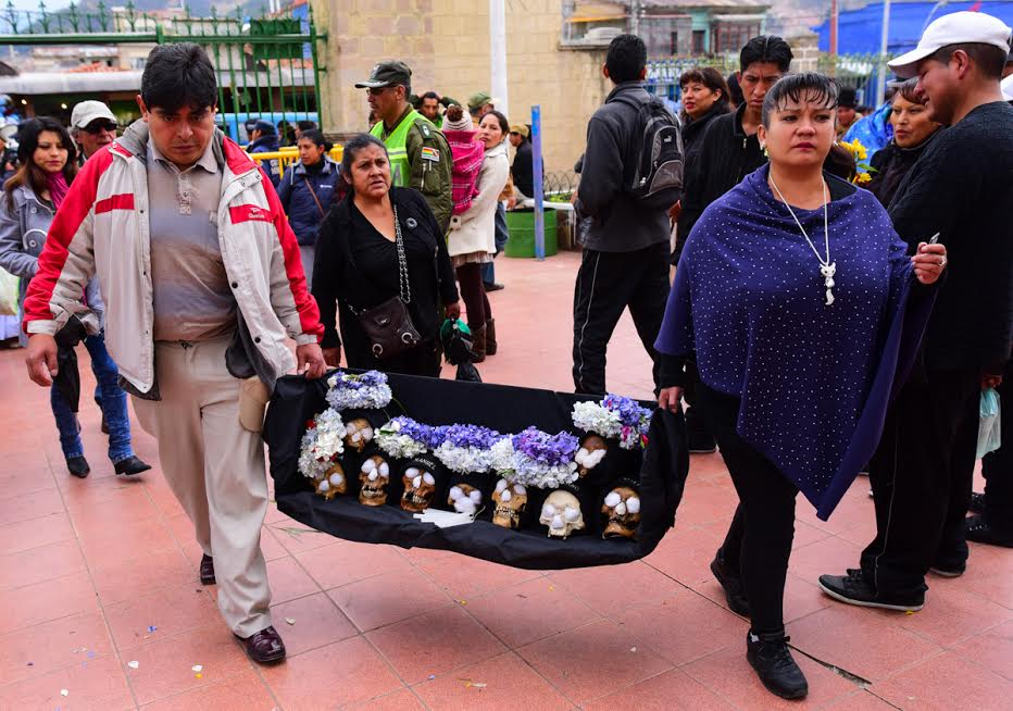 Man and woman carrying a display of ñatita skulls