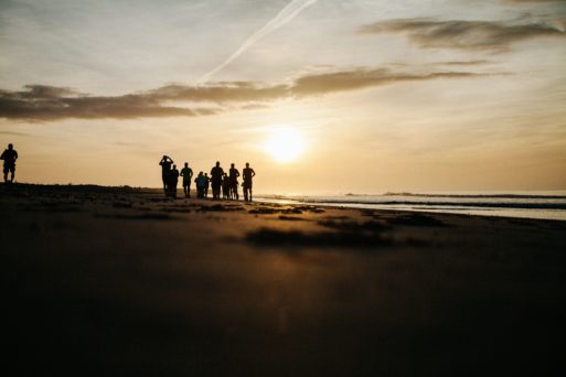 Image of people on a beach at sunset creating new traditions in memory 