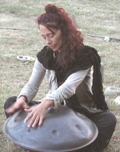 Deb Grant outdoors playing healing music on the handpan