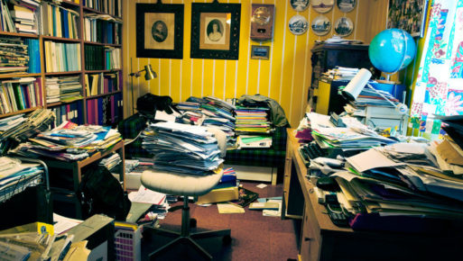 A room filled with papers and clutter needs death cleaning