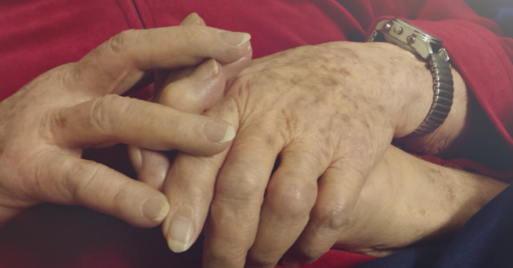 The couple holds hands in "Living and Dying: A Love Story"