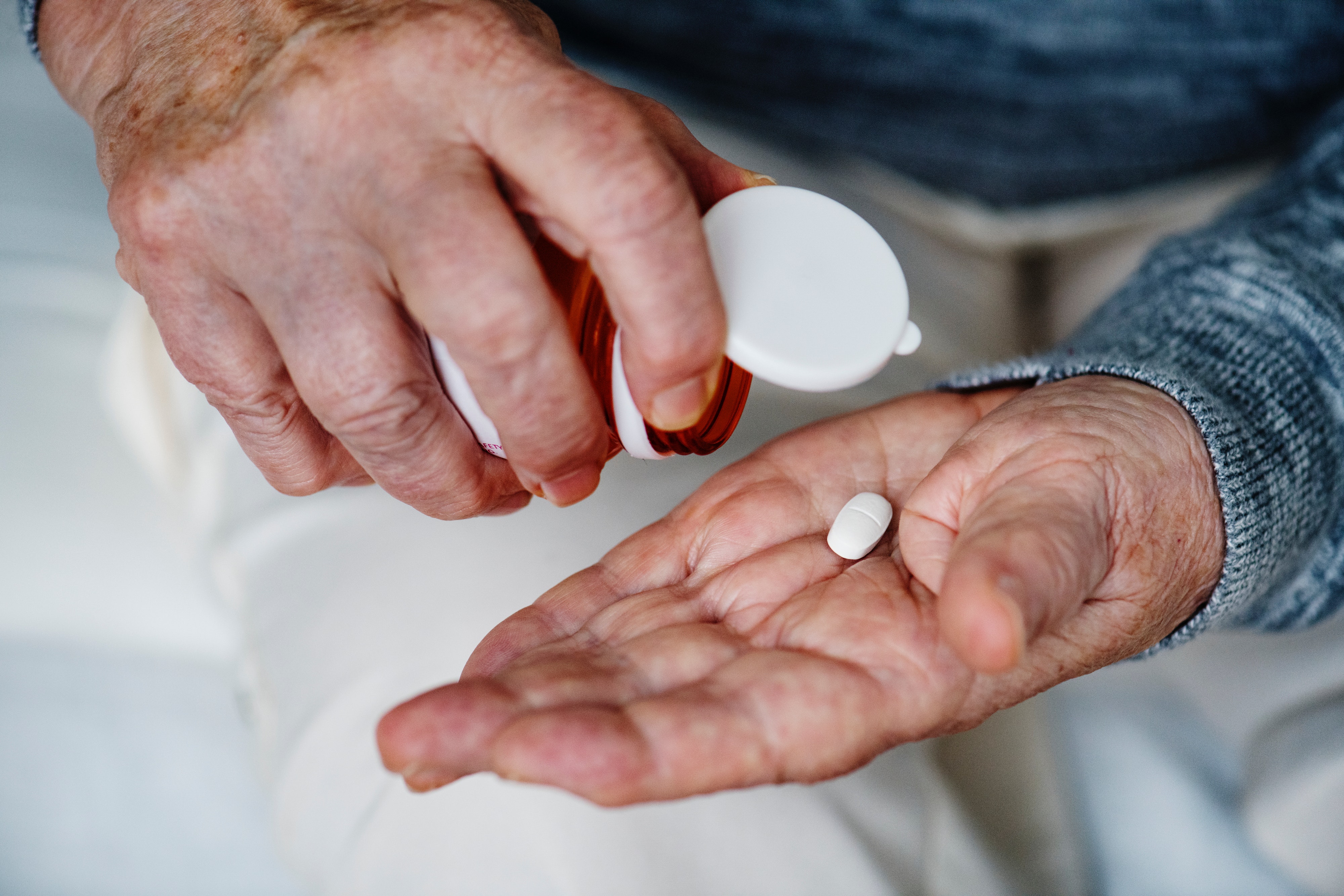 the hands of a man taking his daily aspirin