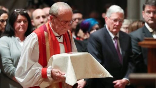 Rev Robinson holds the ashes of Matthew Shepard