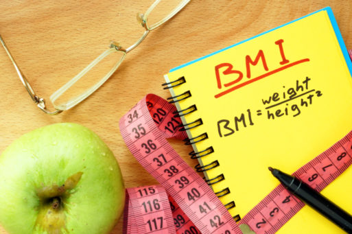 Apple, glasses, tape measure and a notebook that has the BMI equation