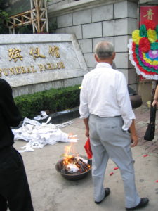 An image of Chinese Funeral Traditions: a fire offering of joss paper 