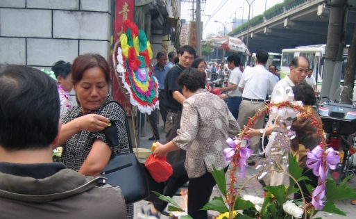 An image of a woman tying a black band on her arm as part of Chinese Funeral Traditions