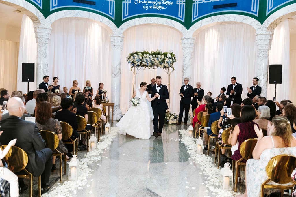 Lindsey Wilkerson and Joel Alsup walking down the aisle on their wedding day at St. Jude's