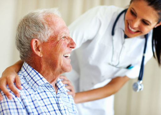 Nurse and elderly patient both smiling representing palliative care