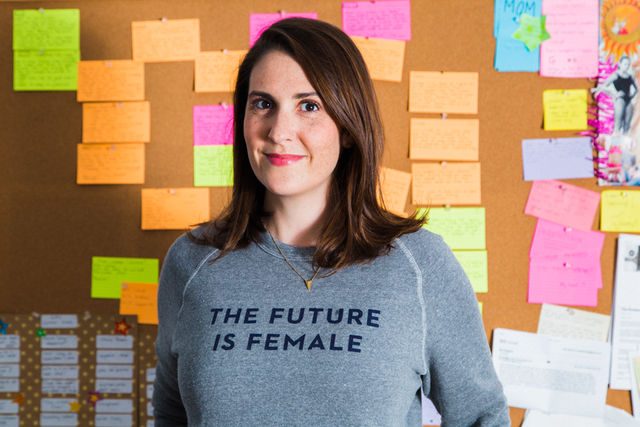 Portrait of Kate Spencer standing in front of bulletin board.