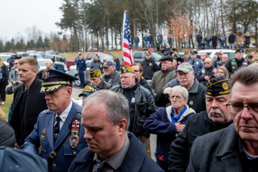 Crowd of veterans and public citizens standing attending Peter Turnpu's funeral.