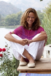 A photo of Joyce Maynard, author of "The Best of Us" sitting by a lake