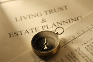 Compass resting on top of a living trust and estate planning document. prepared by a fiduciary