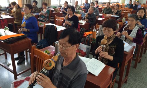 Elderly students in China learning to play a traditional Chinese flute.